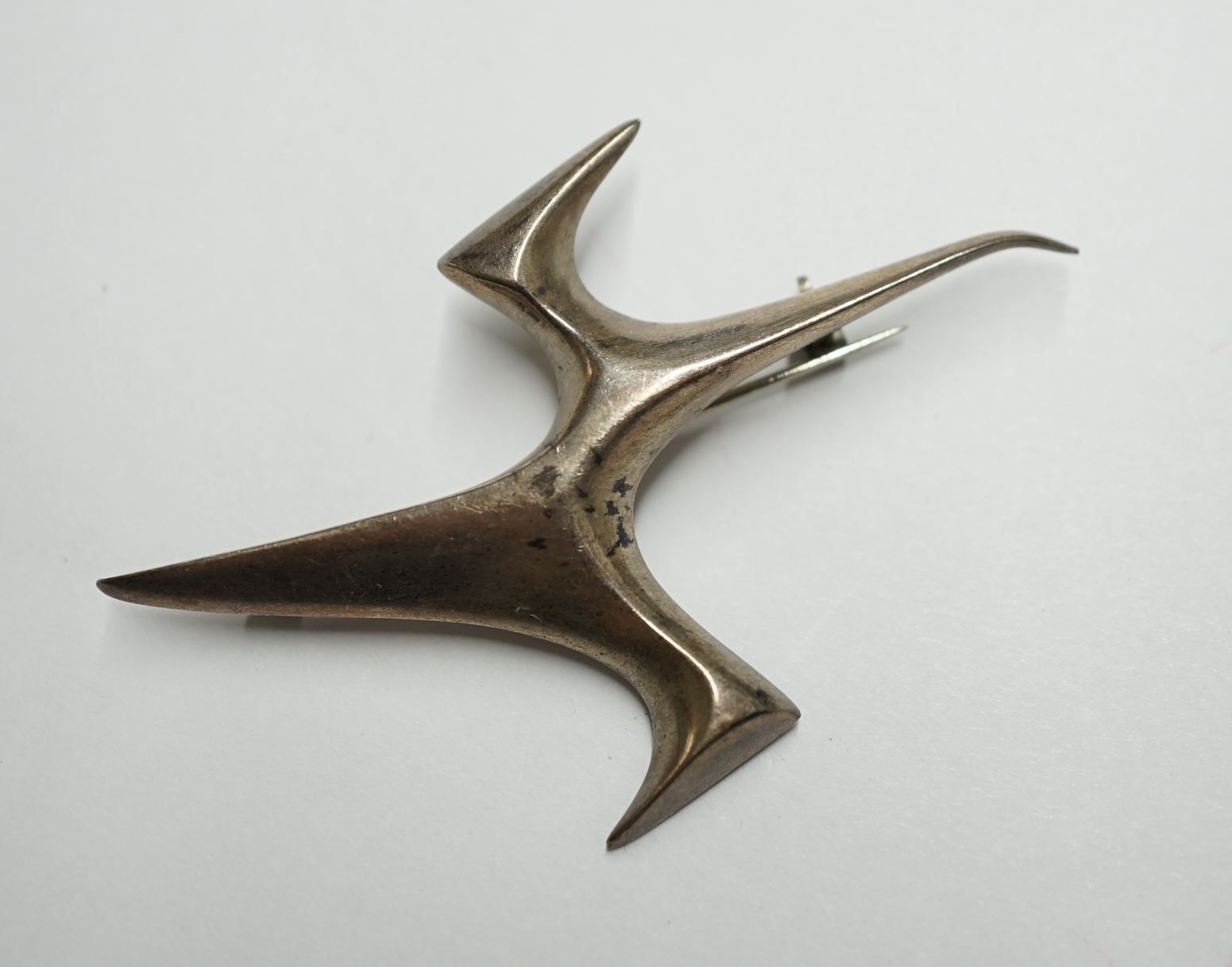 A 1950's Ivan Tarratt modernist silver 'Flight' abstract brooch, Birmingham 1962, designed by Ernest A. Blyth, facsimile signature, 66mm. Condition - fair